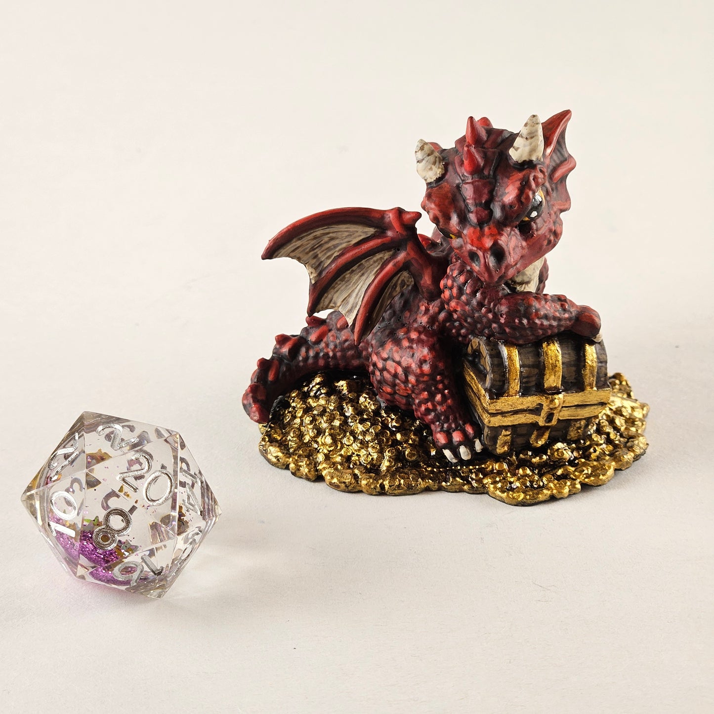 Red baby dragon minature with gold base on a white background d20 view- hand painted by Rissa, roseandshadow.com