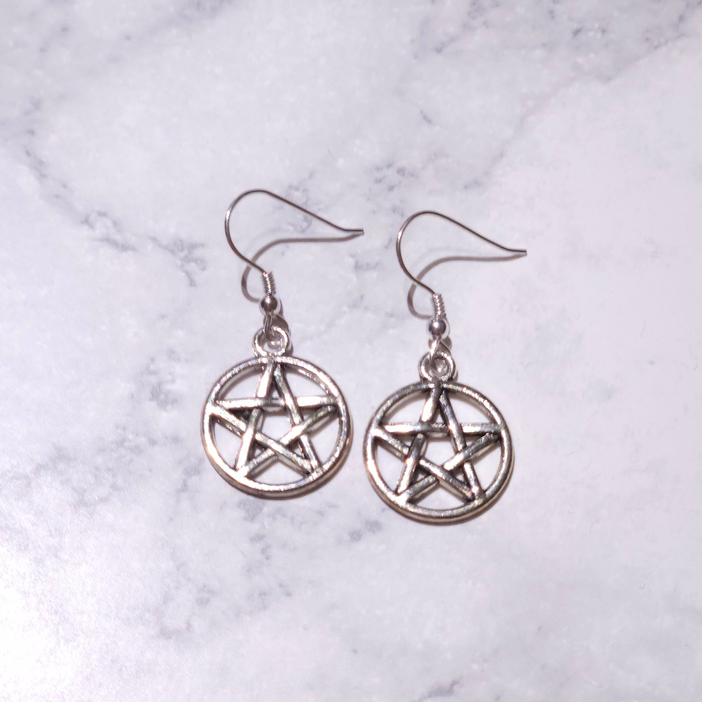 Silver pentacle charm earrings featuring circular pentagram and hanging hooks