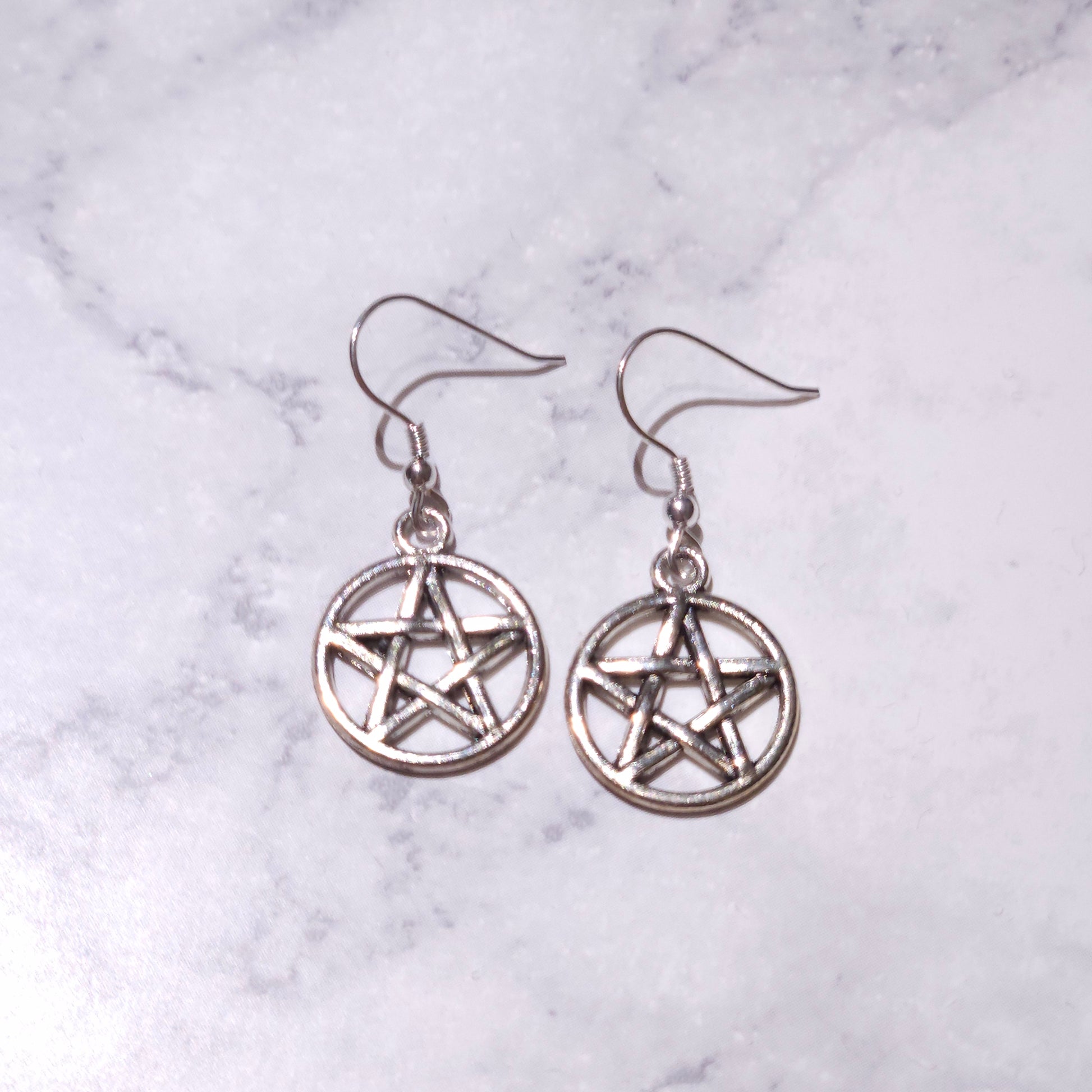 Silver pentacle charm earrings featuring circular pentagram and hanging hooks