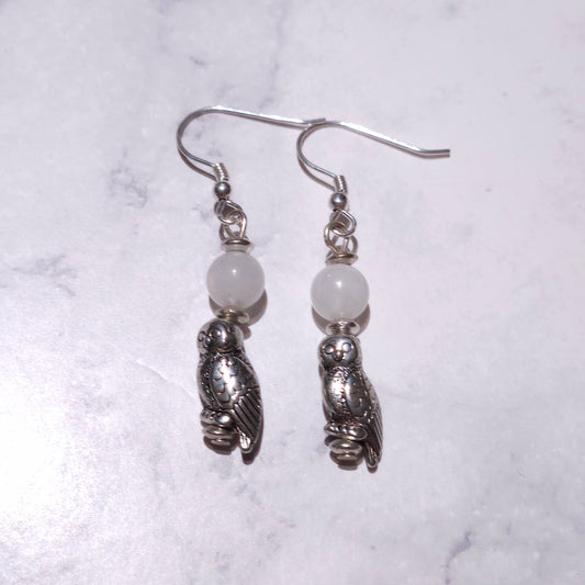Pair of owl charm dangle earrings with pale beads and silver-tone hooks