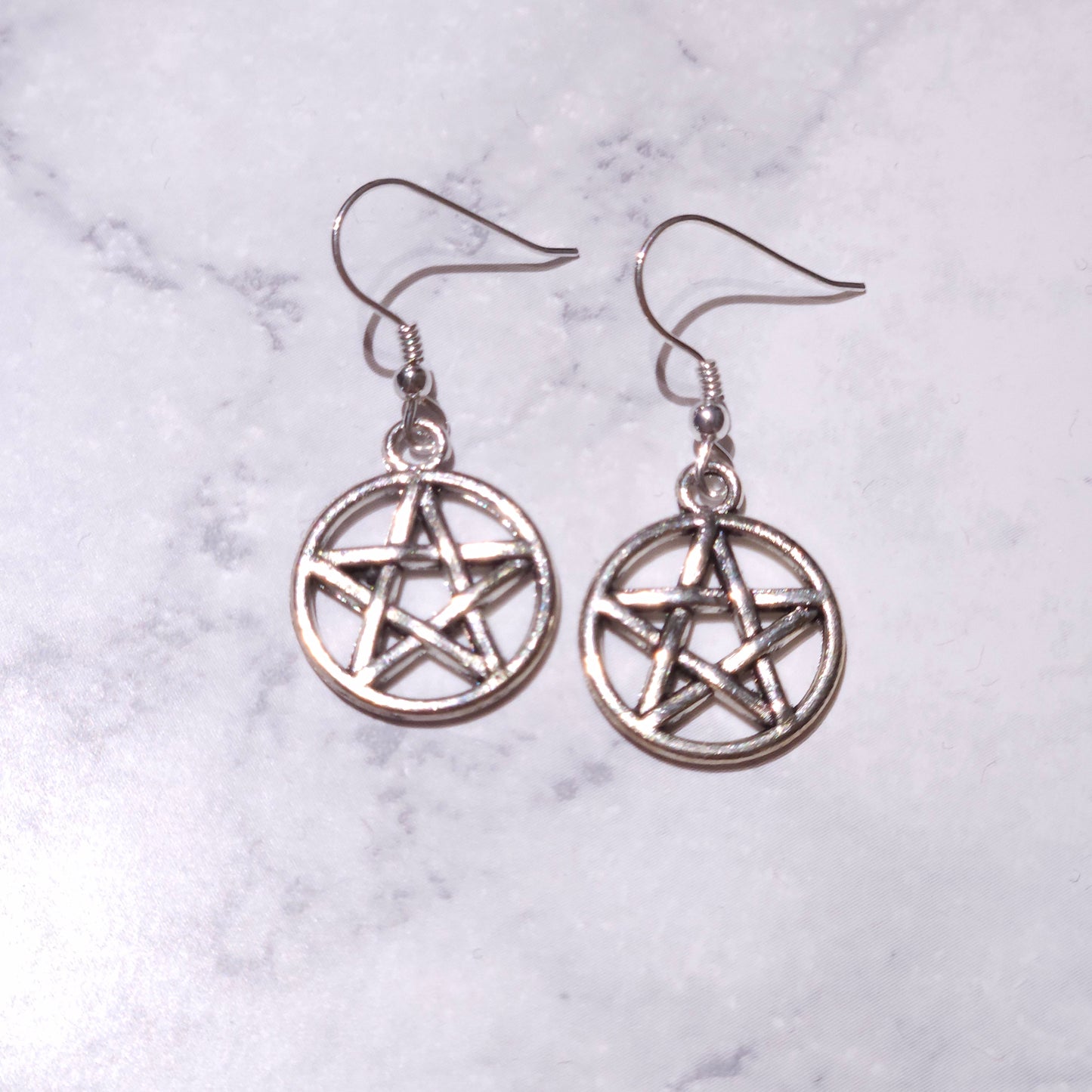 Silver circular pentagram charm earrings with small bead detail and hook drops