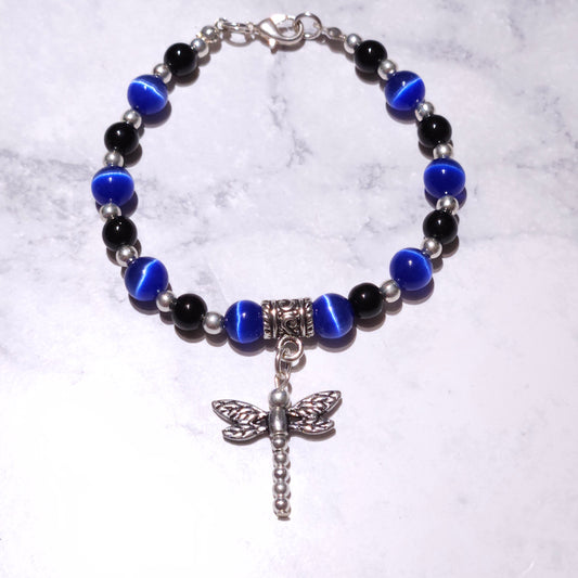 Silver beaded bracelet with black and blue beads, central charm with dragonfly and cross