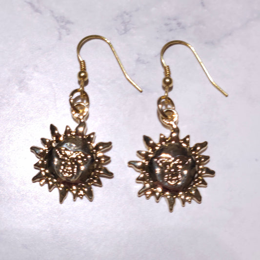 Gold-tone sun charm dangle earrings, round center with spiky rays and hook backs